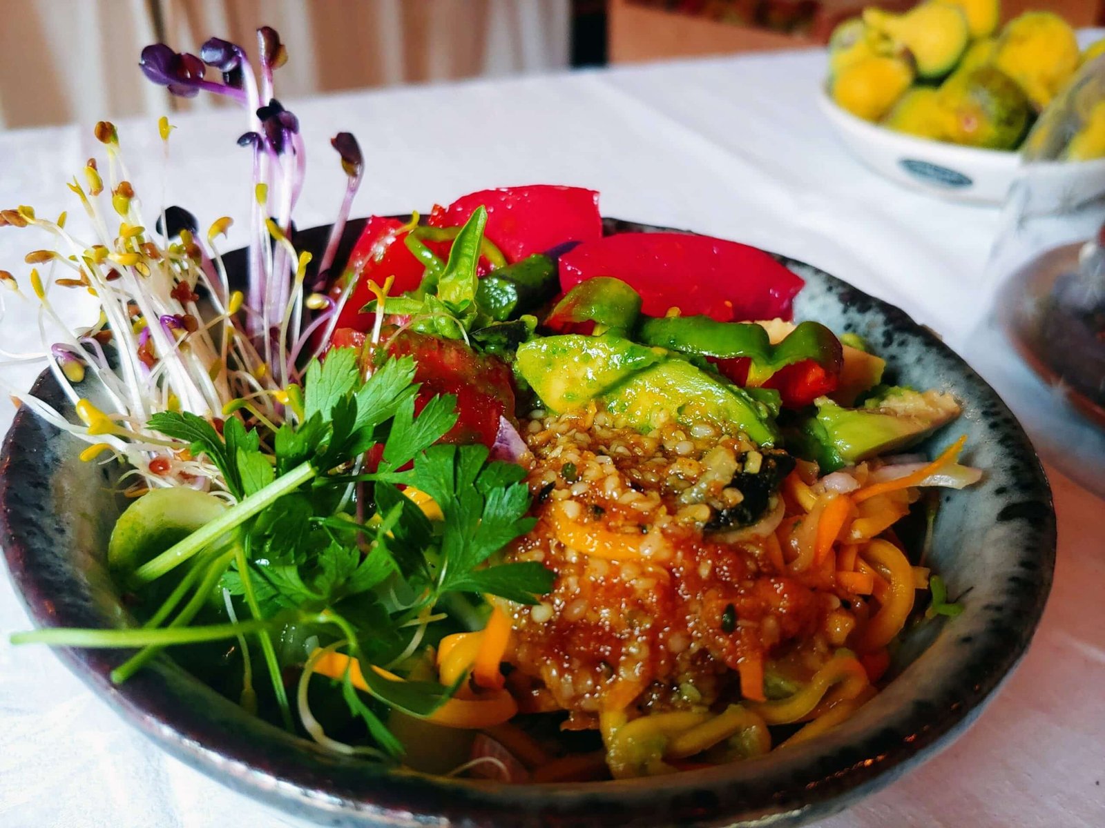 a bowl of food with a salad on a table